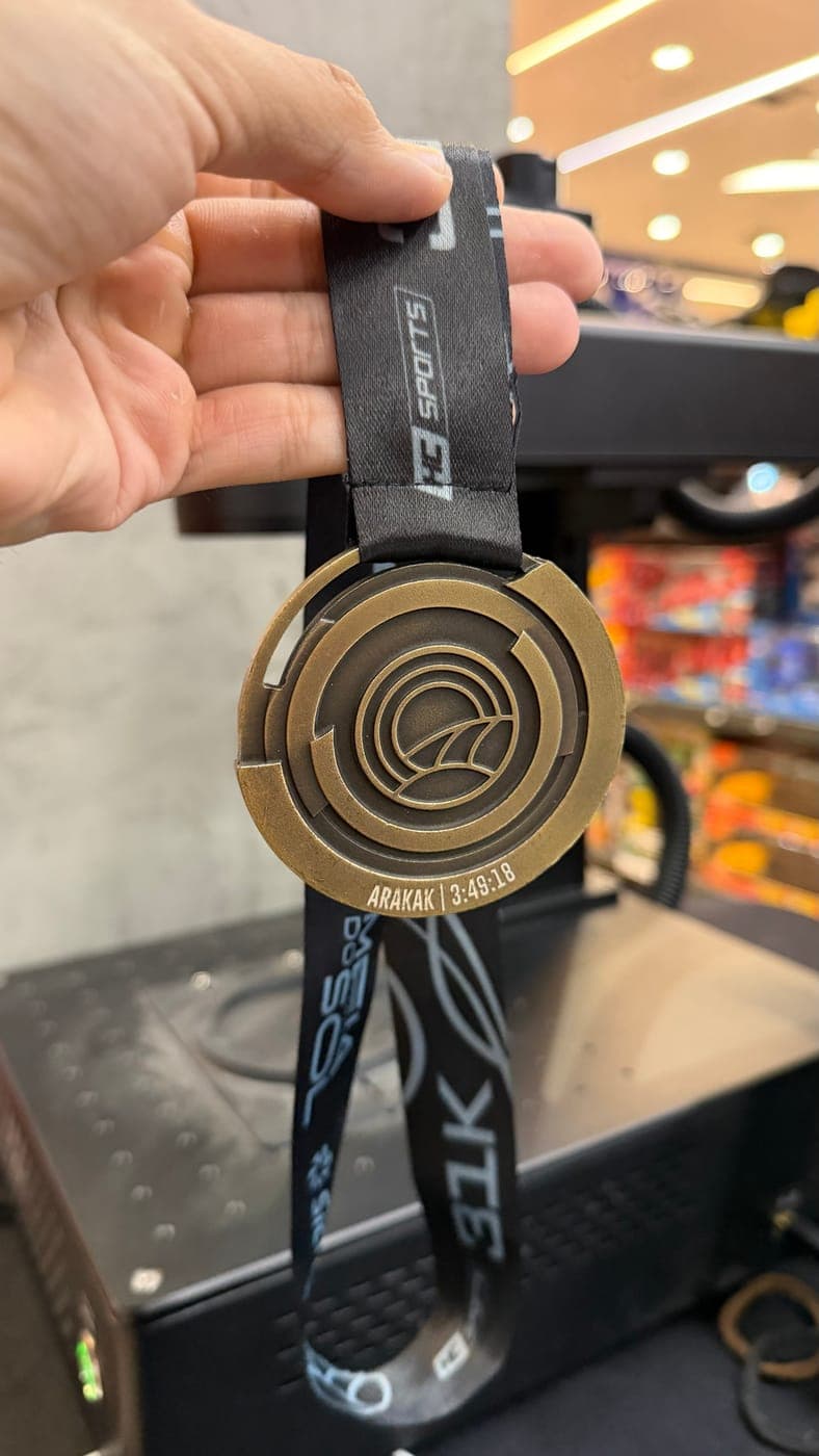 Medalha do desafio recém-gravada, em frente à máquina de laser